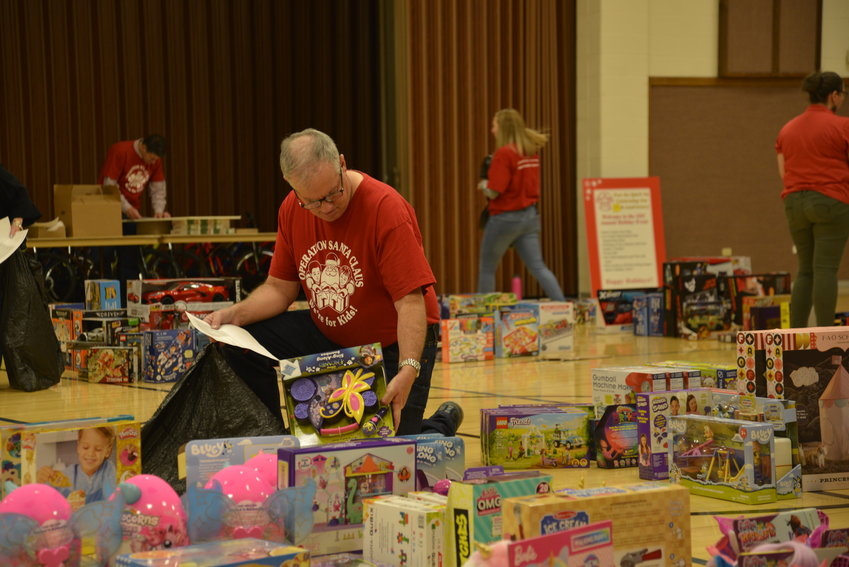 Operation Santa Claus board members bag toys for families.